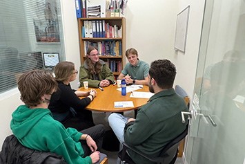 Reynolds and 正规赌钱软件appilbaker (left and right, facing camera) chat with SASS staff and students at the American College of Greece. 